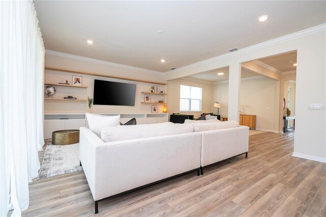 living room featuring ornamental molding and light wood-type flooring