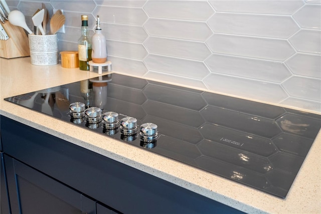 interior details with black electric stovetop and backsplash