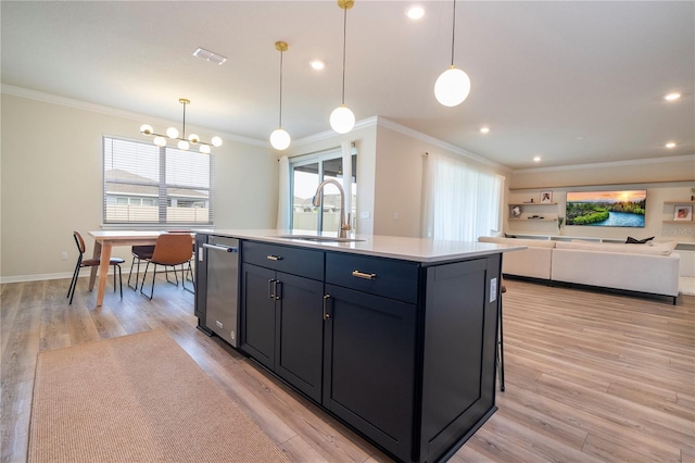 kitchen with a center island with sink, sink, pendant lighting, and light hardwood / wood-style floors