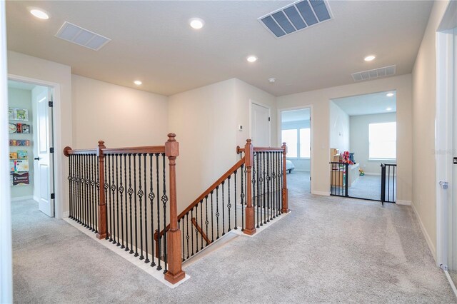 hallway featuring light colored carpet