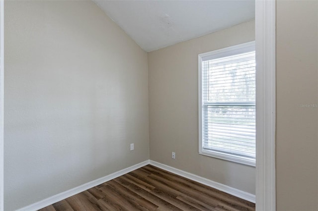 unfurnished room featuring dark wood-type flooring and vaulted ceiling