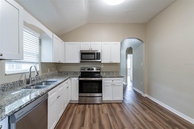 kitchen featuring white cabinets, stainless steel appliances, lofted ceiling, and sink