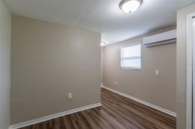 empty room with a wall mounted AC and dark hardwood / wood-style floors