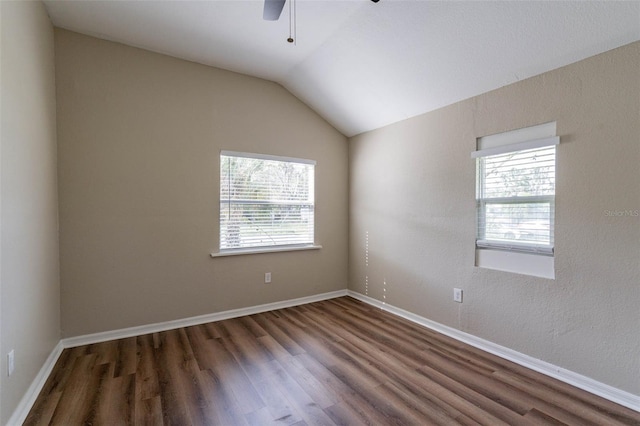 unfurnished room with dark wood-type flooring, a healthy amount of sunlight, and vaulted ceiling