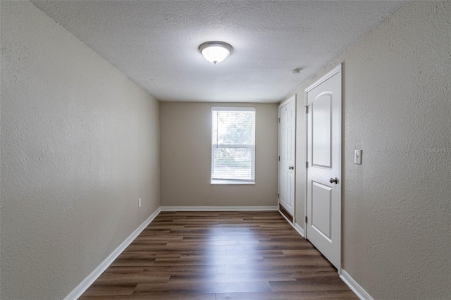 spare room with dark hardwood / wood-style flooring and a textured ceiling