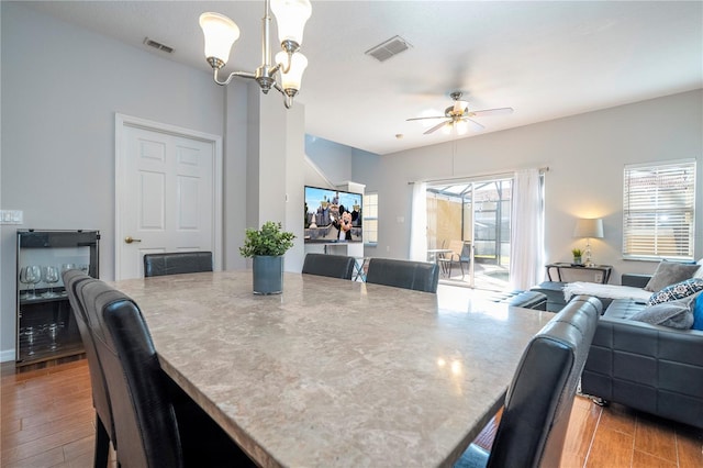 dining area with ceiling fan with notable chandelier and light wood-type flooring