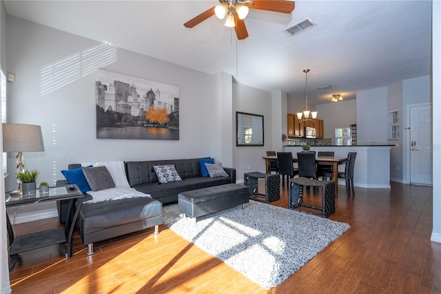 living room featuring wood-type flooring and ceiling fan with notable chandelier