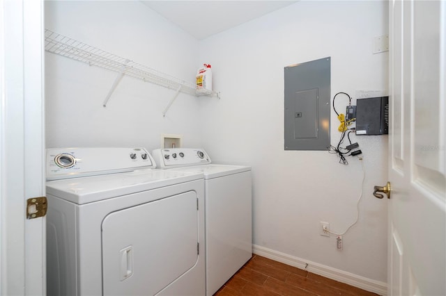 clothes washing area with electric panel, washer and clothes dryer, and dark hardwood / wood-style floors