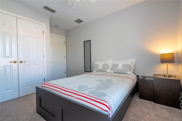 bedroom featuring a closet, light colored carpet, and ceiling fan