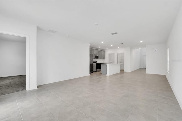 unfurnished living room featuring sink and light tile patterned flooring