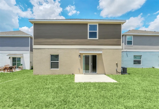 rear view of house with central air condition unit, a patio area, and a lawn