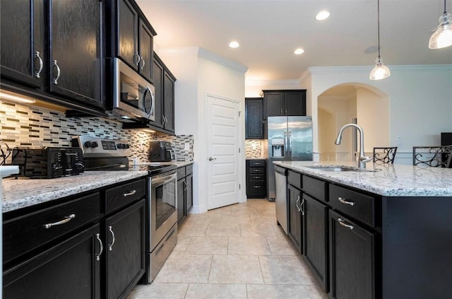 kitchen with a center island with sink, sink, pendant lighting, crown molding, and stainless steel appliances