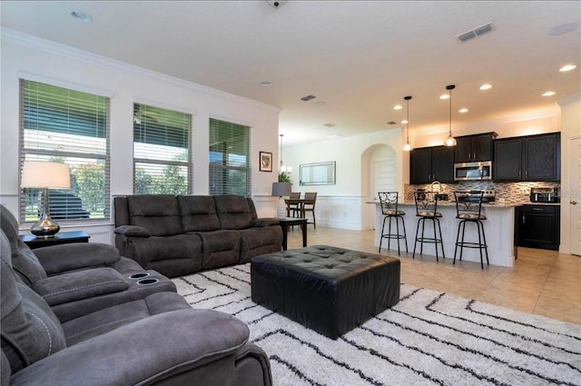 living room with ornamental molding and light tile patterned floors