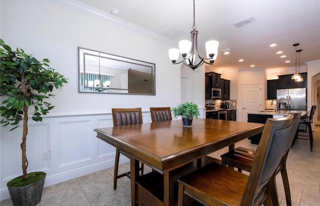 dining space featuring crown molding, a chandelier, and light tile patterned floors