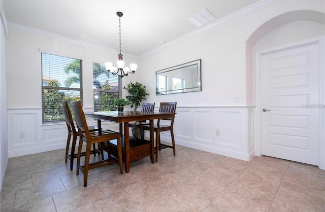 dining space featuring crown molding and an inviting chandelier