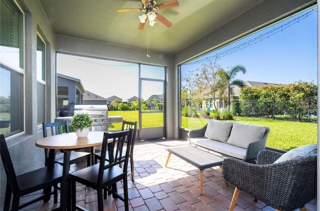 sunroom / solarium featuring ceiling fan