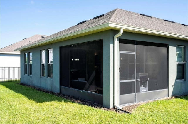 view of home's exterior with a yard and a sunroom