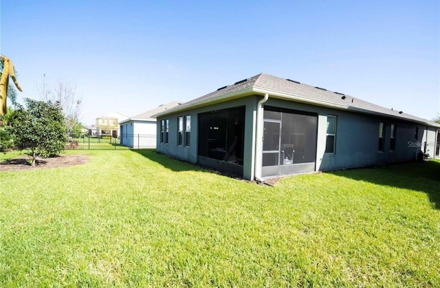 back of house with a yard and a sunroom