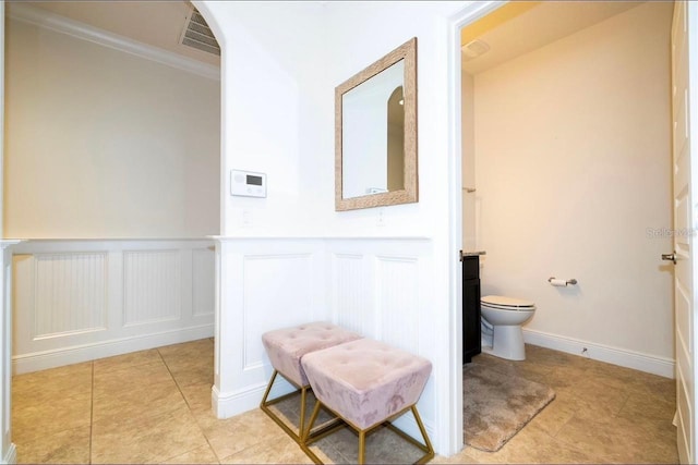 bathroom featuring vanity, tile patterned floors, crown molding, and toilet