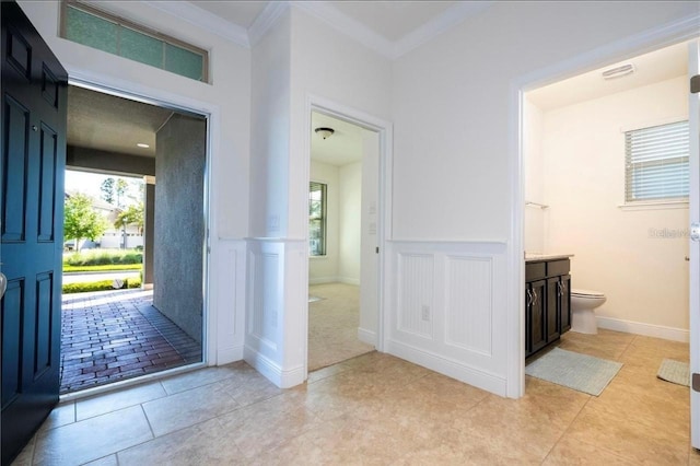 foyer entrance featuring ornamental molding and light tile patterned floors