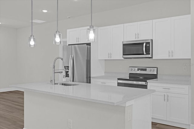 kitchen featuring decorative light fixtures, a kitchen island with sink, and appliances with stainless steel finishes