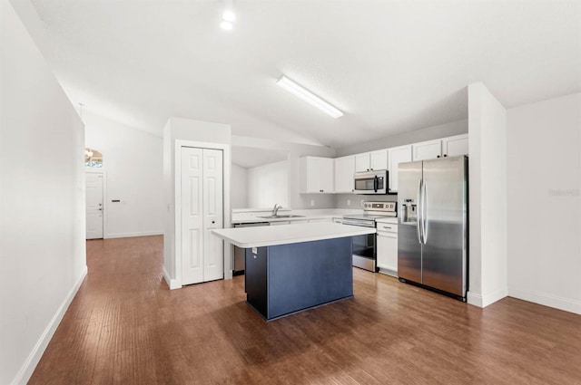 kitchen featuring a kitchen island, dark hardwood / wood-style floors, stainless steel appliances, vaulted ceiling, and white cabinetry