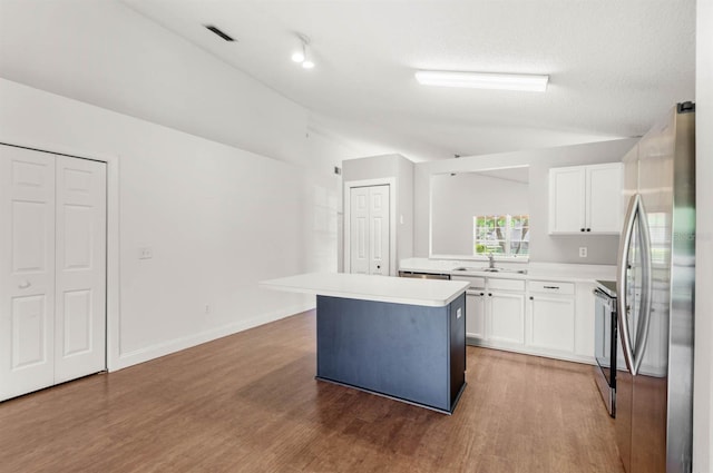 kitchen with hardwood / wood-style floors, a center island, stainless steel appliances, and white cabinetry