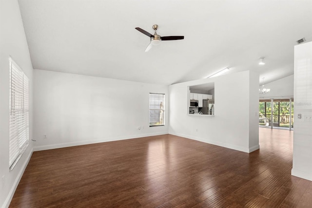 unfurnished living room featuring high vaulted ceiling, dark hardwood / wood-style floors, and ceiling fan with notable chandelier