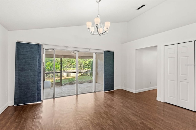 empty room featuring high vaulted ceiling, dark hardwood / wood-style flooring, and an inviting chandelier