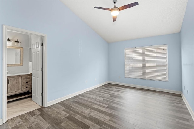 unfurnished bedroom featuring connected bathroom, lofted ceiling, light hardwood / wood-style flooring, a textured ceiling, and ceiling fan