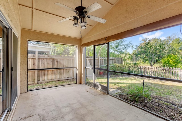 unfurnished sunroom featuring ceiling fan and vaulted ceiling