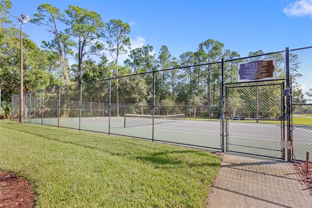 view of tennis court with a yard