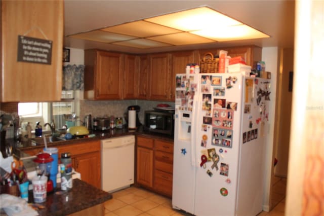 kitchen with tasteful backsplash, sink, light tile patterned floors, and white appliances