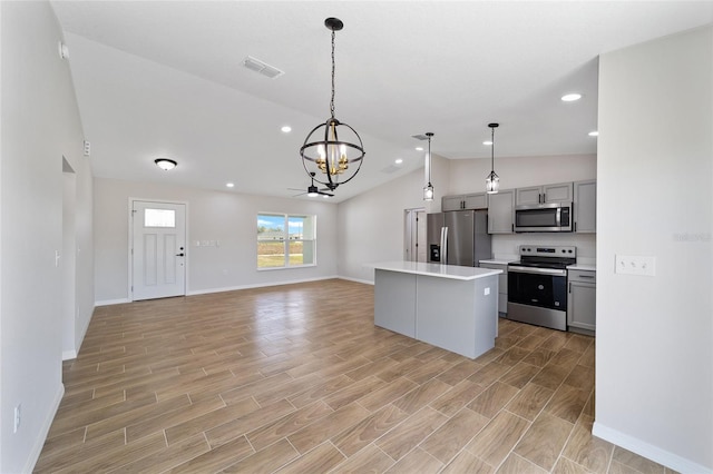 kitchen with stainless steel appliances, gray cabinets, light countertops, and a center island