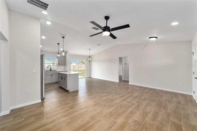 unfurnished living room with wood tiled floor, visible vents, and a ceiling fan