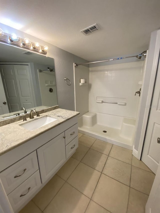 bathroom with vanity, a shower, and tile patterned flooring