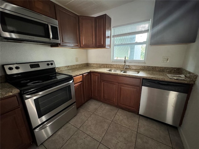 kitchen featuring light tile patterned flooring, appliances with stainless steel finishes, and sink