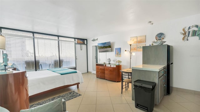 tiled bedroom with a wall of windows and fridge