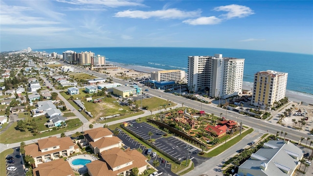 birds eye view of property with a water view and a beach view