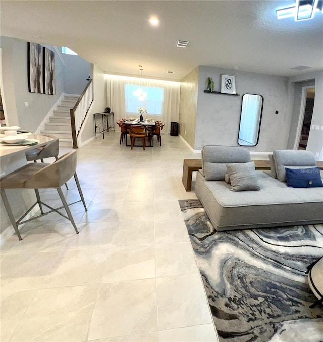 tiled living room featuring a notable chandelier