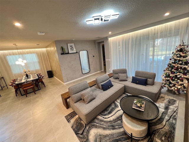 tiled living room with a textured ceiling and a chandelier