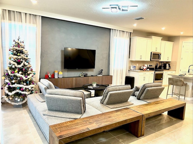 living room featuring a textured ceiling and light tile patterned floors