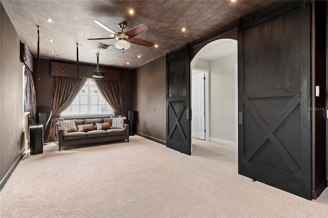 unfurnished room featuring ceiling fan, light colored carpet, and a textured ceiling