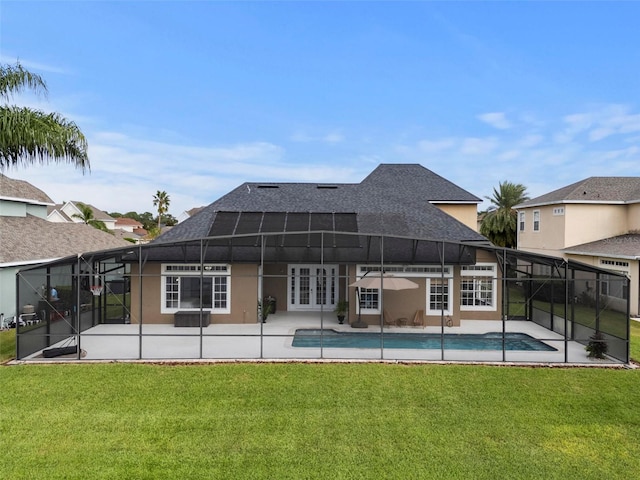 back of property with glass enclosure, a patio area, a yard, and french doors