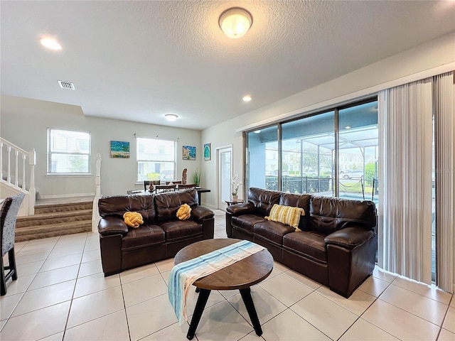 living room featuring a textured ceiling and light tile patterned floors