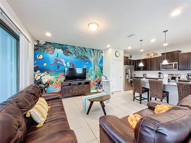 living room with a textured ceiling and light tile patterned floors