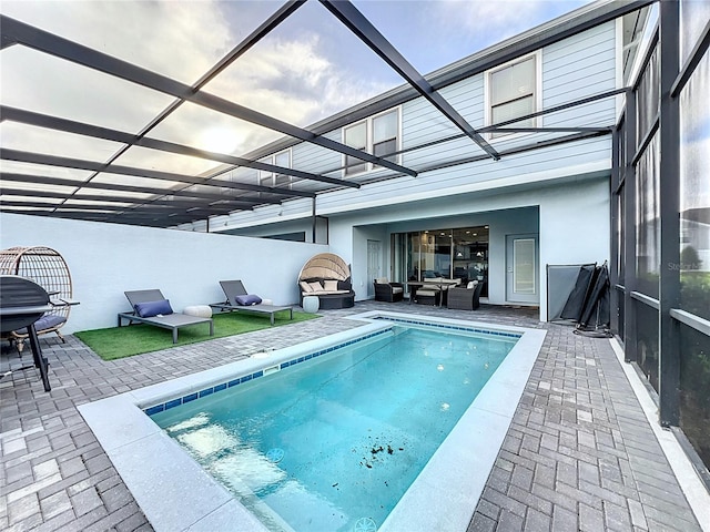 view of swimming pool with a patio and glass enclosure