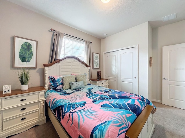 bedroom with a closet, a textured ceiling, and light colored carpet