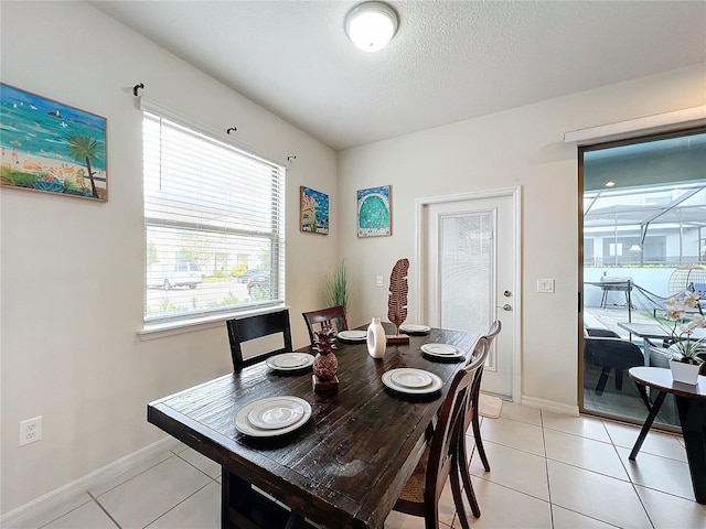 tiled dining room featuring a textured ceiling