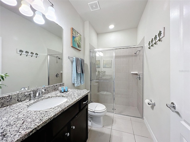 bathroom featuring vanity, tile patterned flooring, toilet, and an enclosed shower